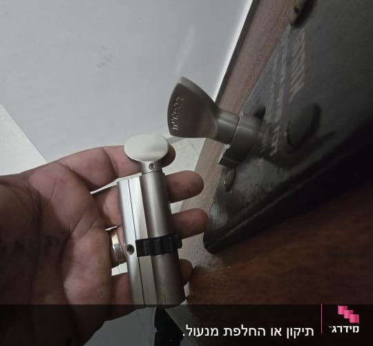 יד מחזיקה צילינדר מנעול ליד דלת